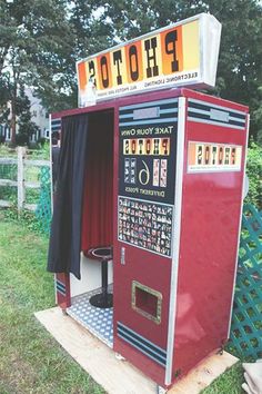 an old fashioned photo booth sitting in the grass