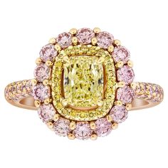 a fancy yellow diamond ring with pink and white diamonds in the center, surrounded by gold accents