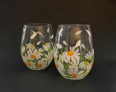 two hand painted wine glasses with daisies on them