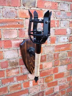 a wall mounted wine bottle holder on the side of a brick building with a corkscrew attached to it