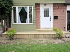 a house with steps leading up to the front door and side porch that has grass growing on both sides