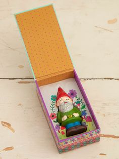 an open box with a small gnome figurine in it