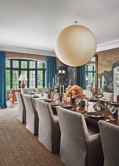 the dining room table is set with place settings for eight people and has blue drapes on the windows