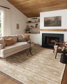 a living room filled with furniture and a fire place under a wooden ceiling mounted above a fireplace