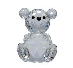 a crystal teddy bear sitting on top of a white surface