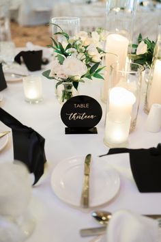 the table is set with white flowers and candles