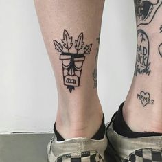 two people with tattoos on their legs and one has a checkerboard design on the leg