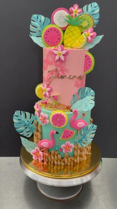 a three tiered cake decorated with fruit and flowers