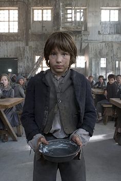 a young boy is holding a plate in an old building