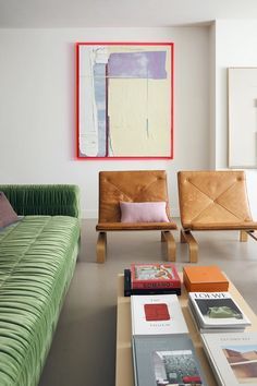 a living room filled with furniture and a painting on the wall