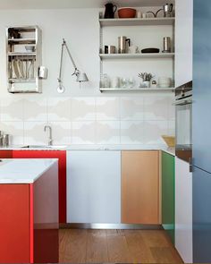 a kitchen with white walls and colorful cabinets