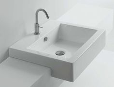 a white bathroom sink sitting on top of a counter next to a wall mounted faucet