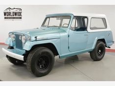 an old blue and white jeep parked in a garage