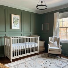 a baby's room with green walls and white crib in the corner, along with a large rug on the floor