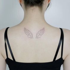 the back of a woman's neck with two wings on it