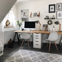 a desk with two chairs and a computer on it