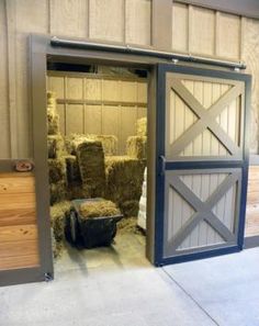 an open barn door with hay bales in it