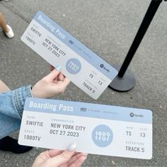 two people are holding up boarding pass tickets