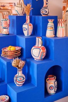 many colorful vases are stacked on top of each other in different shapes and sizes