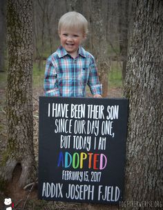 a young boy holding a sign that says i have been their son since our day one, but today i am adopted