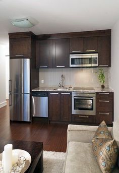 a modern kitchen with stainless steel appliances and wood flooring