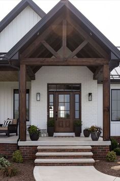 This home has a beautiful front door and porch. The large timber beams look stunning with the white exterior. White Farmhouse Exterior With Cedar Posts, Post And Beam Front Porch, White Siding Exterior, Exterior Entryway Ideas, Front Porch Remodel, White Farmhouse Exterior, Cedar Posts, White Siding, Porch Remodel