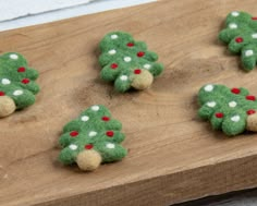 small felt christmas trees on a wooden board