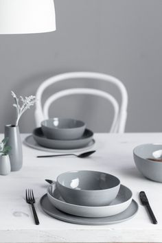 a white table topped with plates and bowls