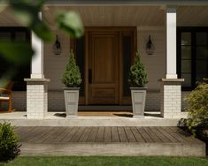 two planters on the front porch of a house