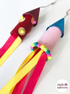 two craft sticks with colored paper on them, one is made to look like a rocket ship