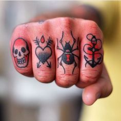 a person with tattoos on their fingers pointing at the camera