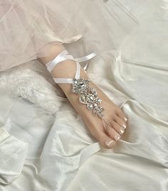 -- Wedding Barefoot Sandals, Bridal Foot Jewelry, Beach Sandals, Silver Rhinestone Foot Jewelry, Footless Sandal- FT049 -- This stunning silver rhinestone footless sandal is the perfect accessory for a beach or garden wedding. This sandal is made clear rhinestone applique and satin ribbon. You can change the satin ribbon color. It can be easily tied around the ankle for a perfectly adjustable and easy fit. It is very comfortable and adjustable. Model in photo above is a US Size 7.5 . **This list Elegant Wedding Toe Post Sandals, Adjustable Rhinestone Barefoot Sandals For Wedding, Wedding Barefoot Sandals With Rhinestones, Silver Rhinestone Barefoot Sandals For Summer, Elegant Rhinestone Barefoot Sandals For Summer, Adjustable Rhinestone Barefoot Sandals For Party, Rhinestone Barefoot Sandals For Party, Wedding Sandals With Rhinestones And Single Toe Strap, Adjustable Rhinestone Barefoot Sandals For Summer