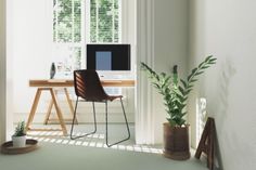 a room with a desk, chair and computer on the table in front of it