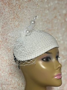 Simple, yet elegant. White Beaded Fascinator half hat trimmed with veiling/net, and hat pin. The hat pin is for decorative purposes only. The hat is affixed to the head via a hatstring. The hat measures approximately 9.75 in X 6.75 inches at its widest parts. PLEASE NOTE All items for Free Shipping will be shipped via USPS First Class Mail. Gifts for mom, sister, wife, or yourself. Gatsby Style Mini Hat Headband For Weddings, White Gatsby Style Fascinator For Evening, White Gatsby Style Fascinator For Weddings, White Headband Mini Hats For Church, White Mini Hat Headband For Church, Elegant Adjustable Hats With Bead Caps, Elegant Evening Headpieces With Bead Caps, Elegant Fascinator For Mother Of The Bride, White Fascinator With Structured Crown For Party