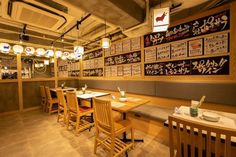 a restaurant with wooden tables and chairs in front of menus hanging on the wall