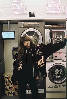 a woman standing in front of a washing machine