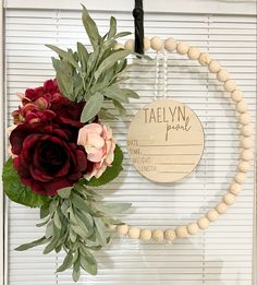 a wooden beaded wreath with flowers on it and a sign that says tawny park