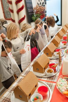 a group of people standing around a table with boxes on it and food in front of them