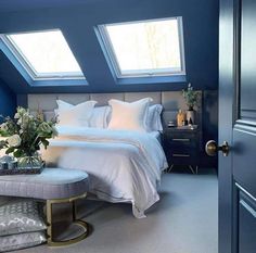 a bedroom with two skylights above the bed and a bench in front of it