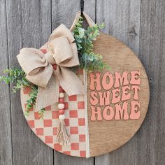 a wooden sign with the words home sweet home on it and a bow attached to it