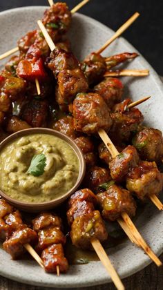 meat skewers with dipping sauce on a plate