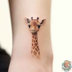 a small giraffe tattoo on the side of a woman's leg,