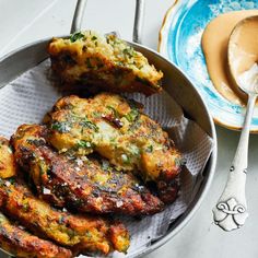 some food is sitting in a bowl on a table next to a fork and spoon