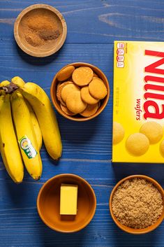 the ingredients to make peanut butter cookies laid out on a blue wooden table with bananas