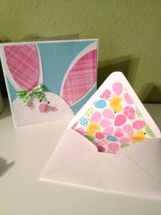 an open envelope with a card inside and a bunny in the corner, on top of a table