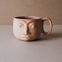 a ceramic cup with a face on it