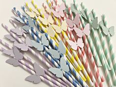 many different colored paper straws with butterflies on them