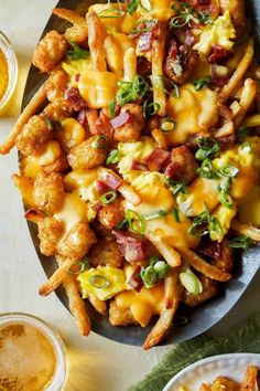 a plate filled with cheesy tater tots and fries