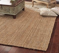 a living room with wooden floors and large rugs on the floor next to a coffee table