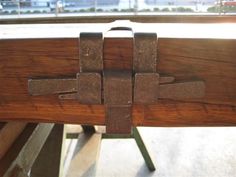 a wooden bench with metal straps on it